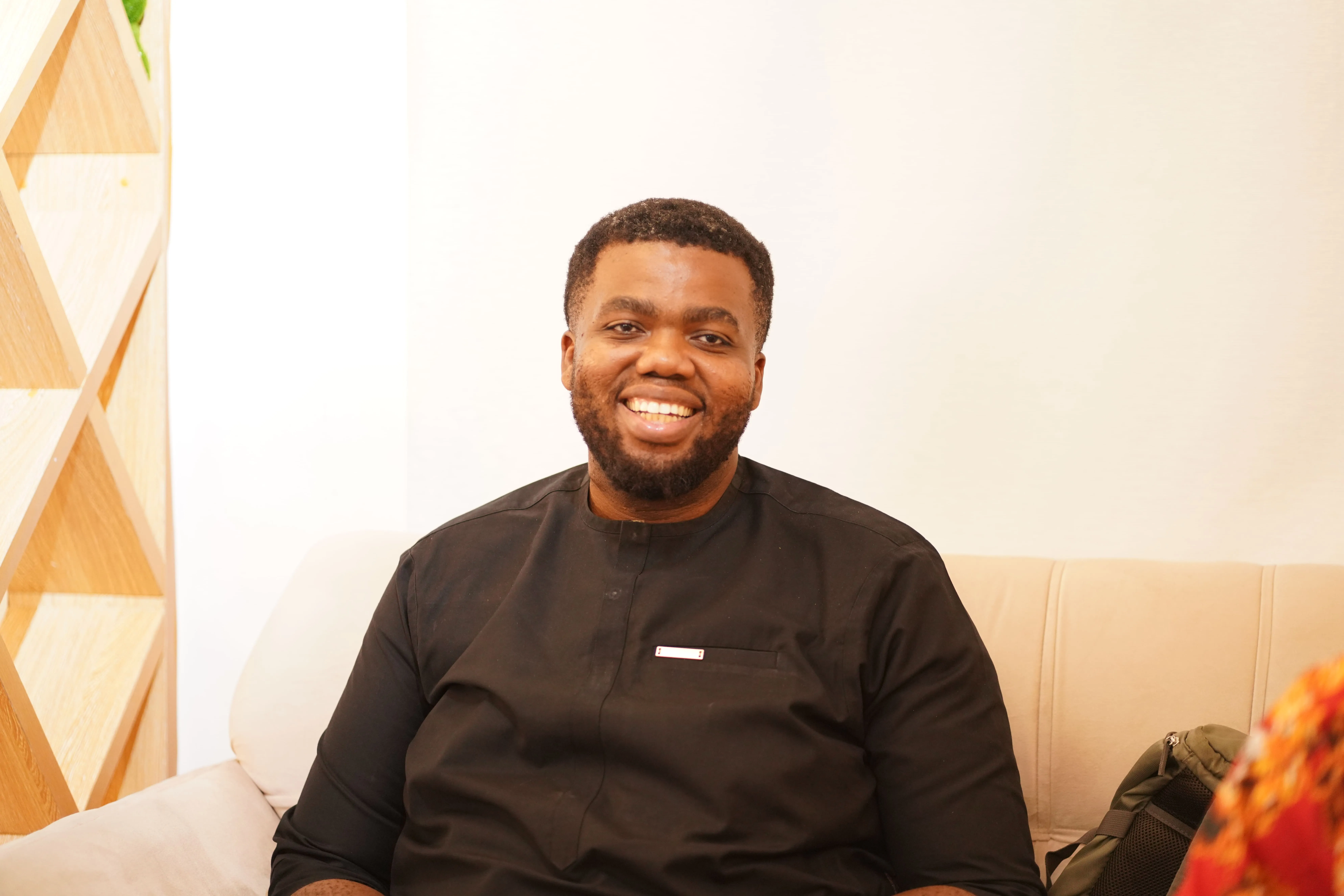 A man sitting on a couch with a smile on his face.