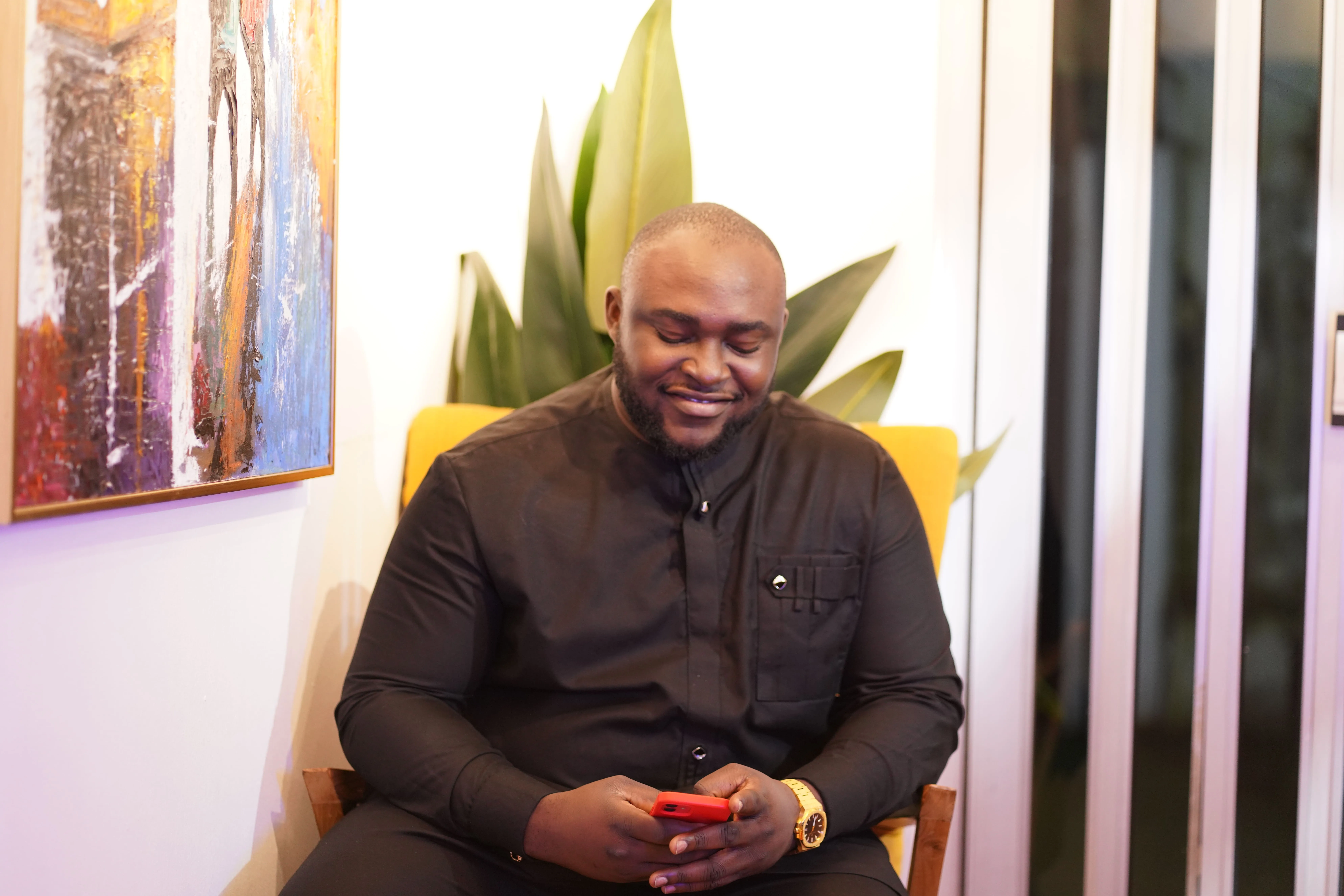 A man sitting in a chair holding a cell phone.