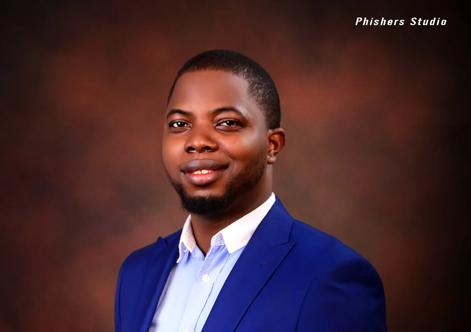 A photo of Joseph Olaiya in a blue suit posing for a picture.
