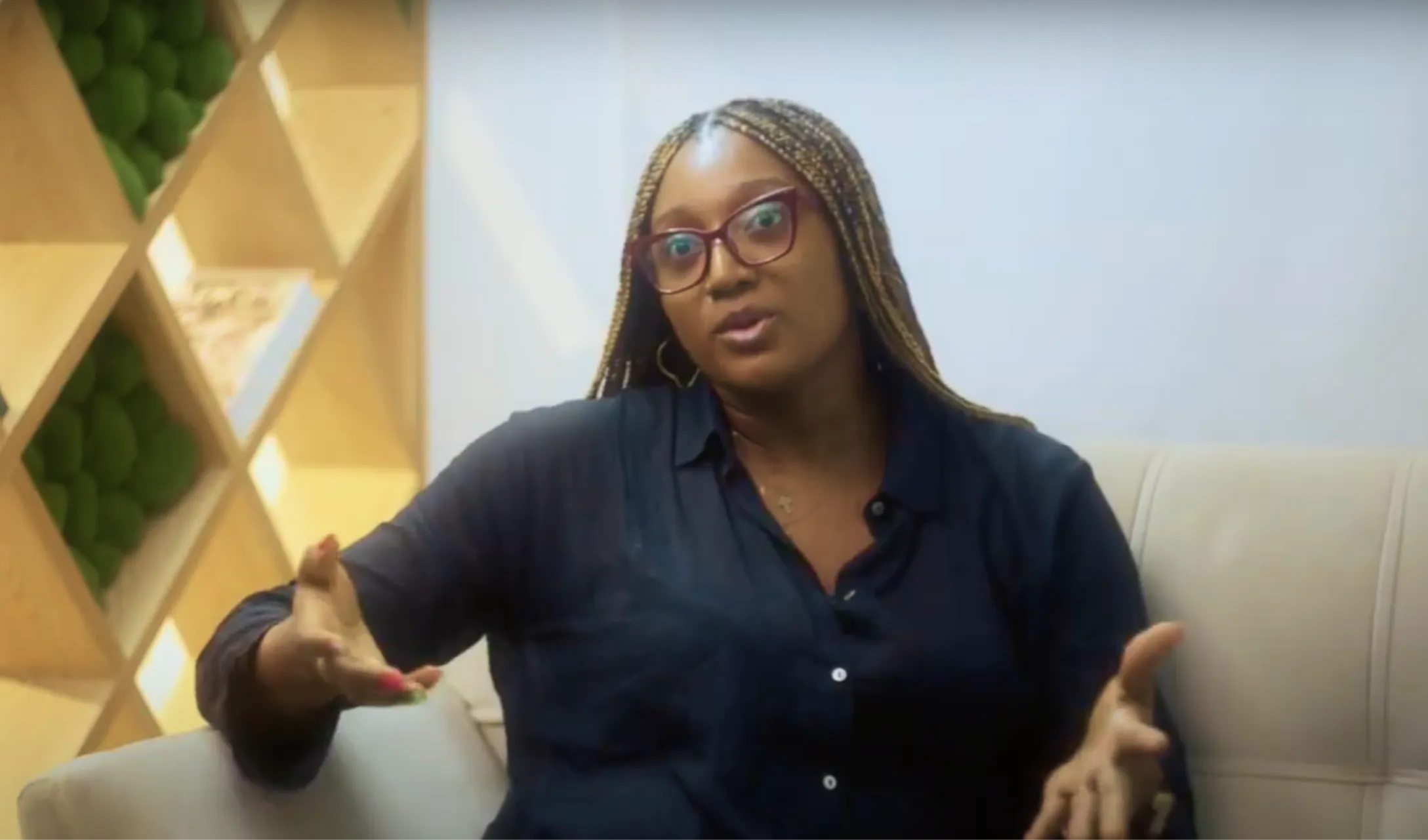 Nancy with glasses sitting on a couch.